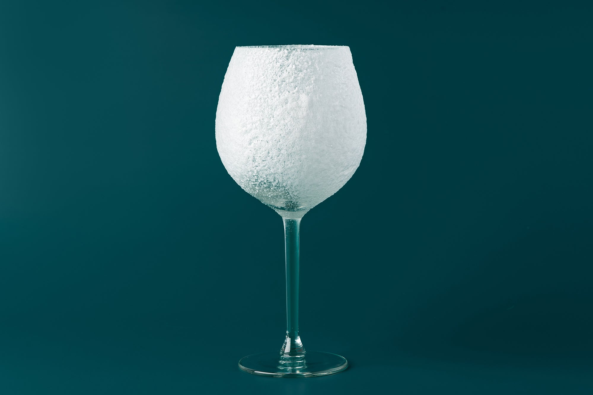 does wine freeze: frozen wine glass on green background