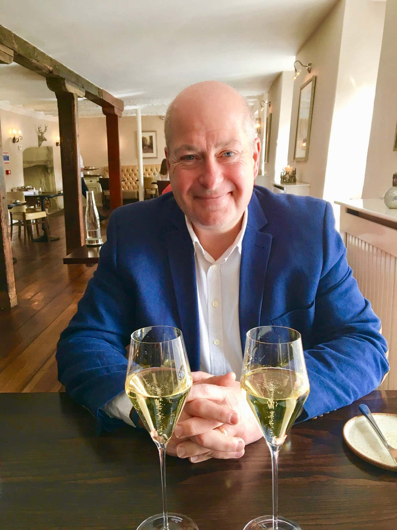Mike Lawton wine lover reviewer at restaurant with 2 glasses of champagne