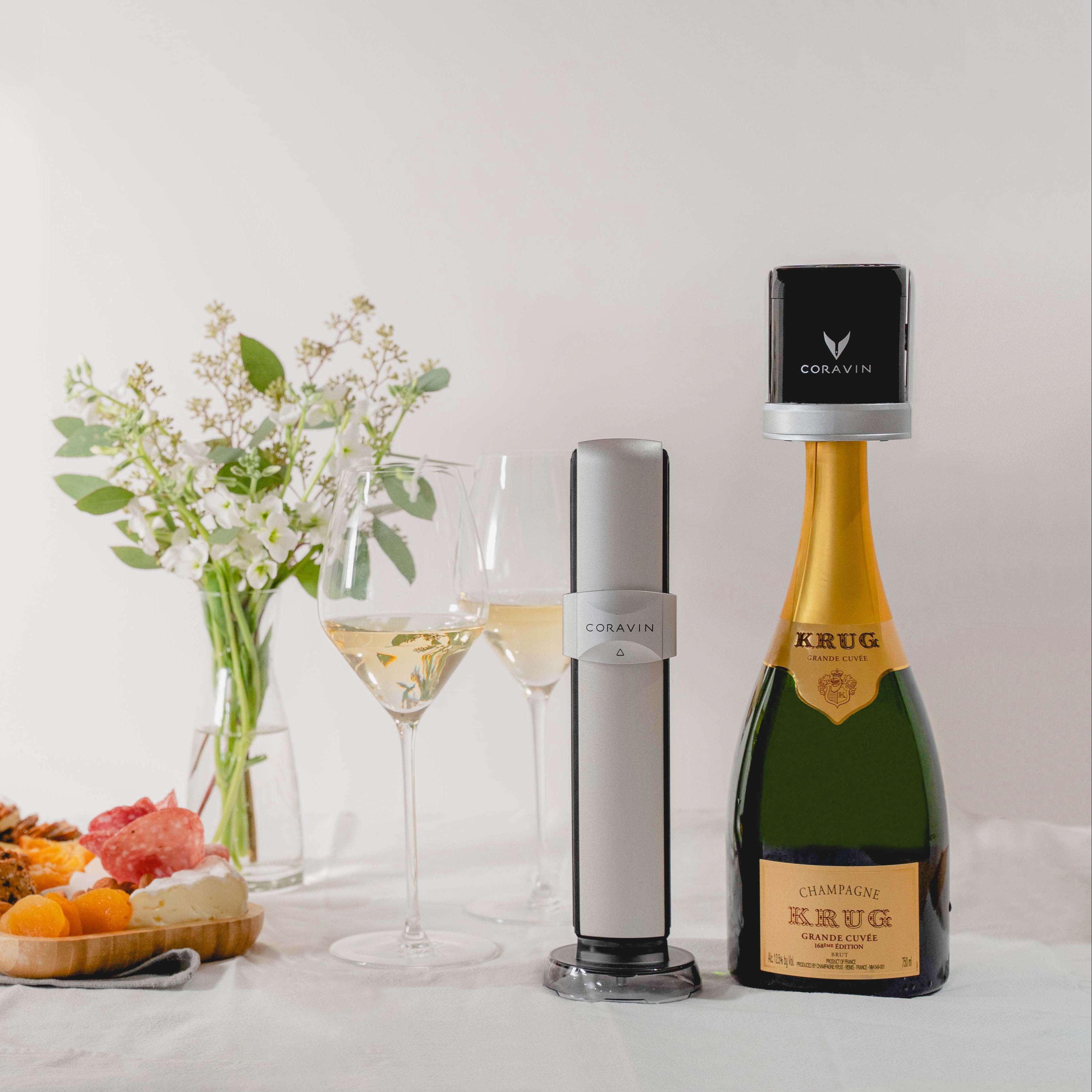 Coravin Sparkling wine by-the-glass system with Krug champagne against white background