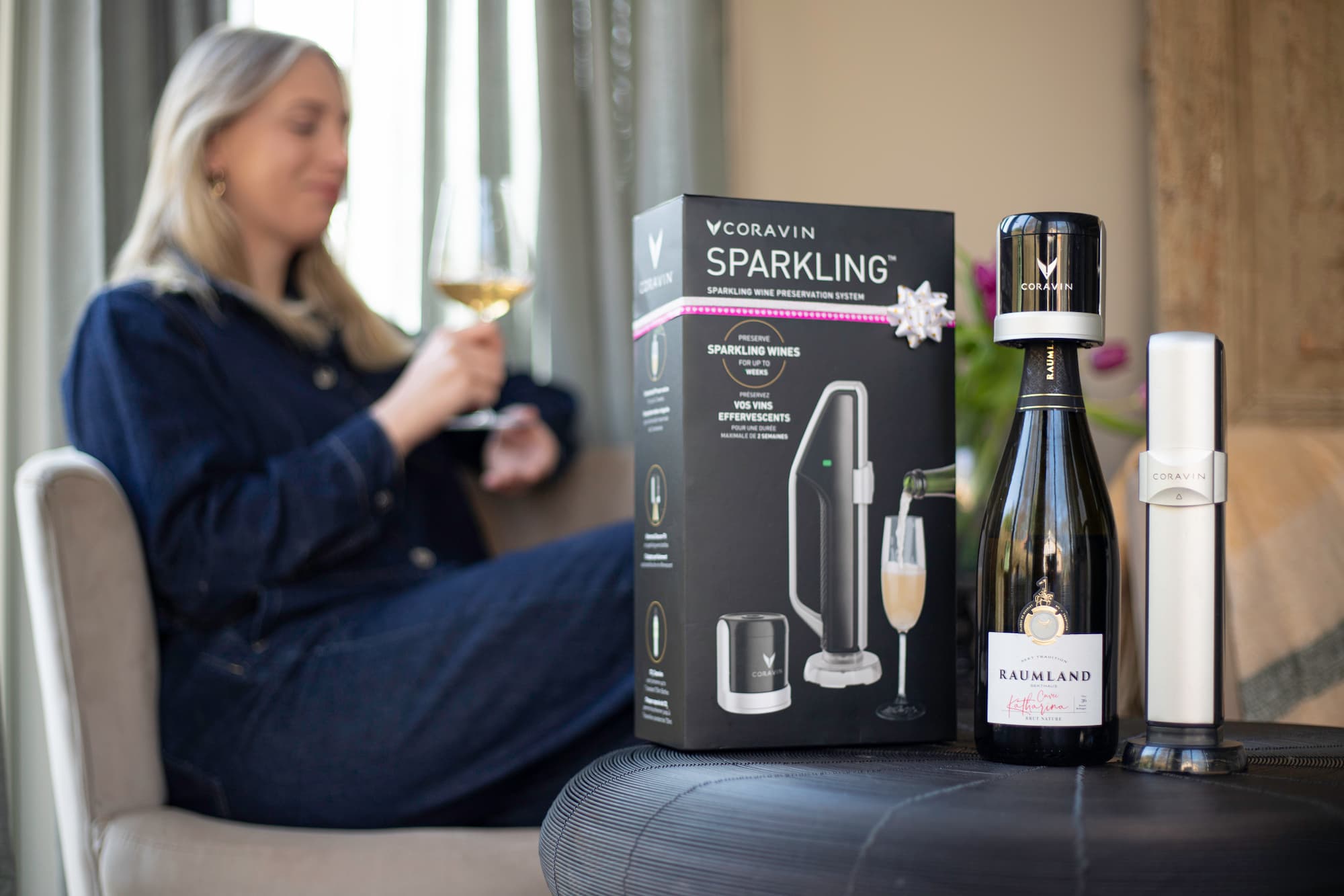 Woman enjoying a glass of sparkling wine at home, with a Coravin Sparkling Wine Preservation System