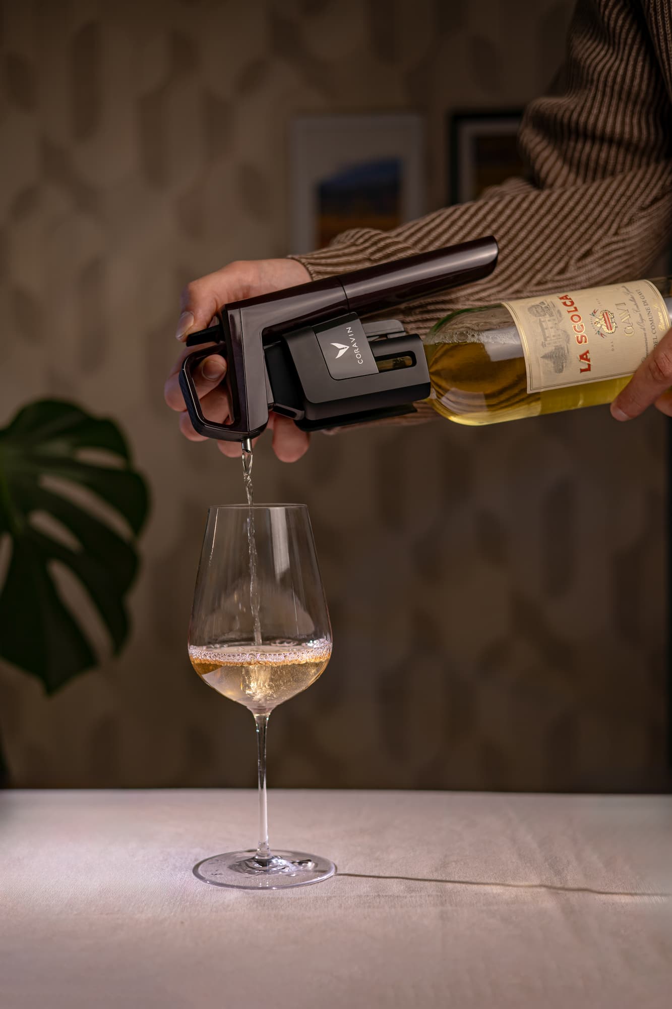 Person using a Coravin wine Timeless system to pour white wine  into a glass, suggesting premium wine service